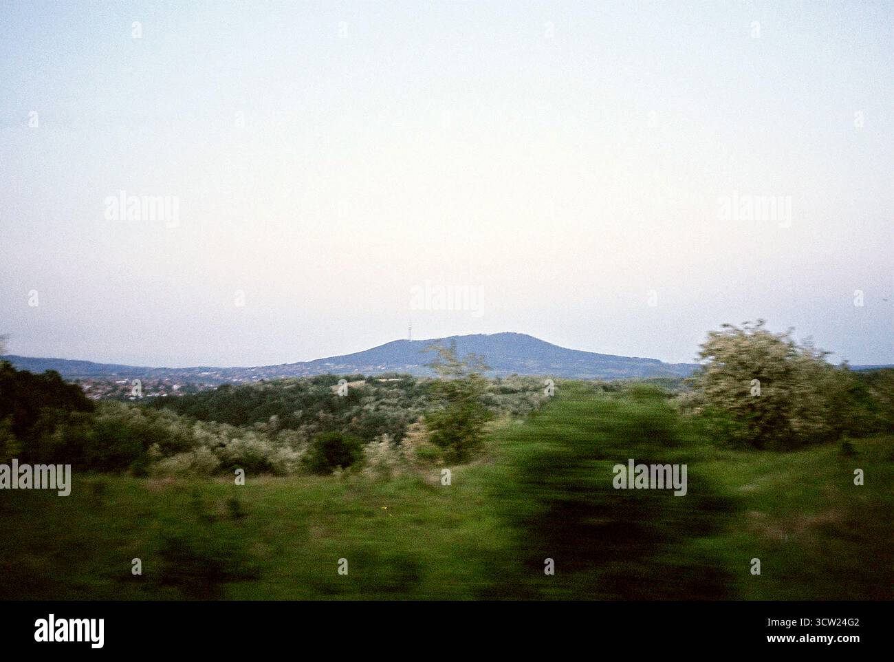 Analoges 35-mm-Foto des Avala Tower aus einem fahrenden Auto an einem bewölkten Tag. Atmosphärische und dokumentarische Reiseszene aus Serbien. Stockfoto