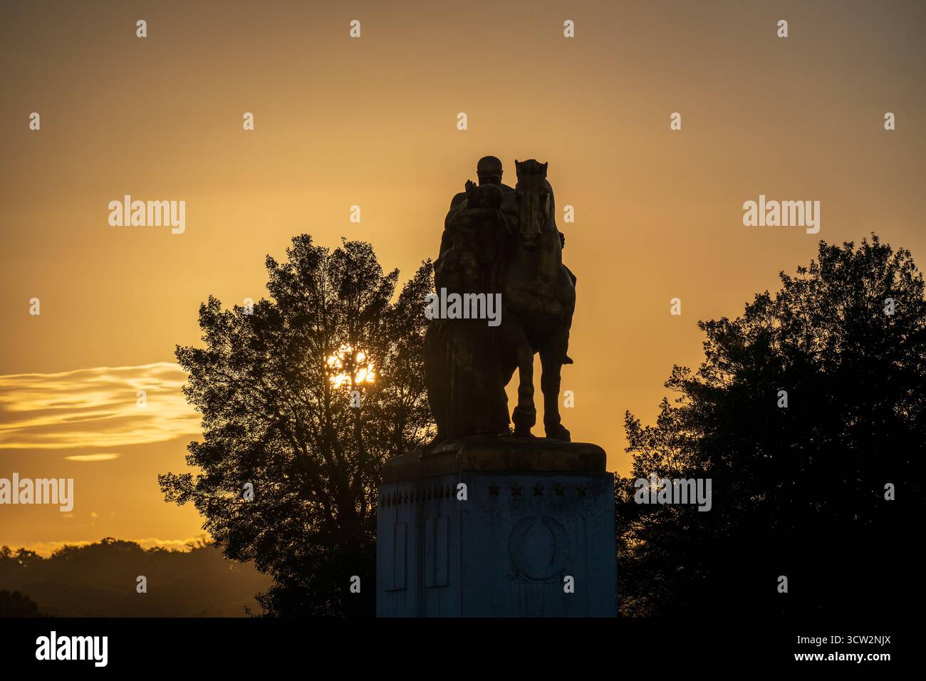 Opferstatue Arlington Memorial Bridge Washington DC // WASHINGTON DC – die Bronzestatue Opfergabe, Teil der Arts of war Skulpturen von Leo Friedlander, ist vor dem Sonnenuntergang auf der Arlington Memorial Bridge geschildert. Dieses 1951 eingeweihte Denkmal befindet sich auf der Seite von Washington D.C. und ergänzt seine Doppelstatue Valor auf der Seite von Virginia. Die Skulpturen der Kunst des Krieges symbolisieren die militärische Stärke und den Einsatz der Nation. Die Arlington Memorial Bridge überspannt den Potomac River und verbindet Washington D.C. mit Arlington, Virginia. Stockfoto