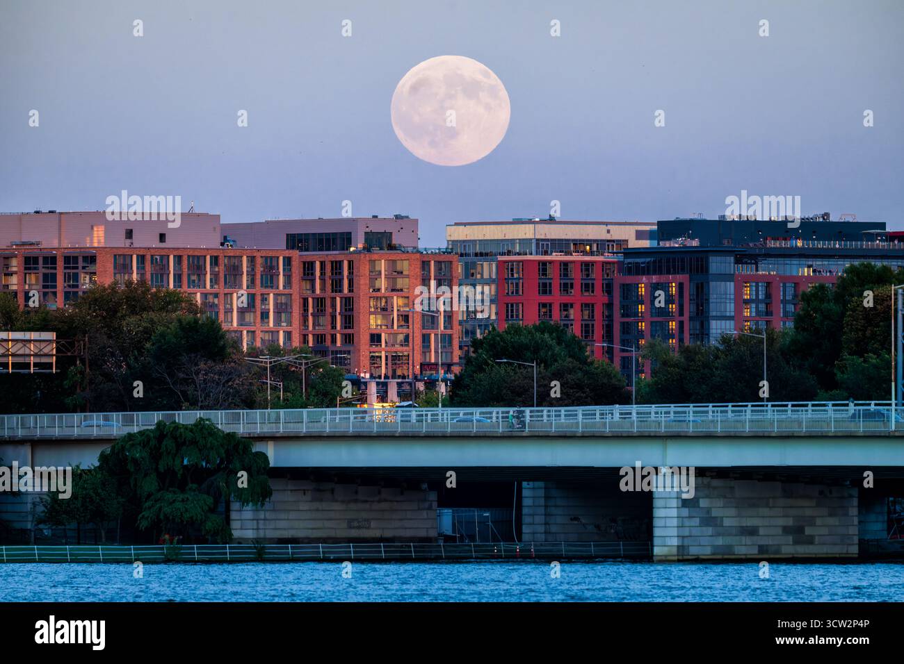 Harvest Moon über der Skyline der Südwestküste Washington DC // WASHINGTON DC — der Harvest Moon vom Oktober 2025 steigt am 6. Oktober 2025 über die 14th Street Bridge und die Gebäude der Skyline der Südwestküste auf. Der 14th Street Bridge Complex, offiziell Arland D. Williams Jr. Die Memorial Bridge erstreckt sich über den Potomac River und verbindet Washington DC mit Arlington, Virginia. Die Southwest Waterfront ist ein schnell umentwickeltes Viertel, das Teil des größeren Südwest-Quadranten der Stadt ist. Der Erntemond ist der Vollmond, der der herbstlichen Tagundnachtgleiche am nächsten kommt. Stockfoto