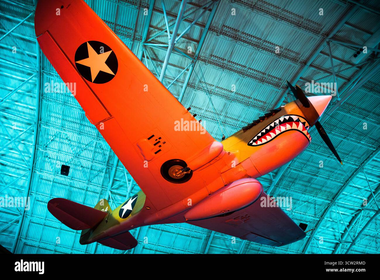 Curtiss P40 Warhawk Aircraft Smithsonian Air and Space Museum Chantilly Virginia // CHANTILLY, Virginia, Vereinigte Staaten — das haienhafte Curtiss P-40E Warhawk (Kittyhawk IA) Kampfflugzeug wird im Steven F. Udvar-Hazy Center ausgestellt. Das 1939 gebaute einmotorige, einsitzige Flugzeug wurde 1941 als Kittyhawk I nach Kanada geliefert. Es wurde 1975 restauriert, um eine P-40E der 75th Fighter Squadron, 23rd Fighter Group, 14th Air Force zu repräsentieren, die an die „Flying Tigers“-Flugzeuge aus dem Zweiten Weltkrieg erinnert. Das halbmonocoque-Ganzmetall misst 330 x 970 cm, 26 Stockfoto