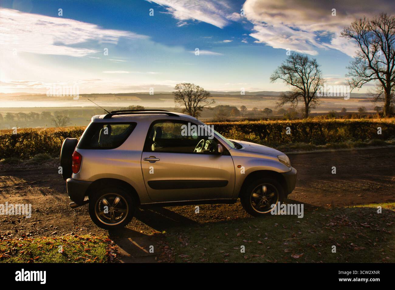 Ein Toyota Rav 4, beleuchtet von der frühen Morgensonne an einem kalten nebeligen Wintermorgen in Perthshire, Schottland. Stockfoto