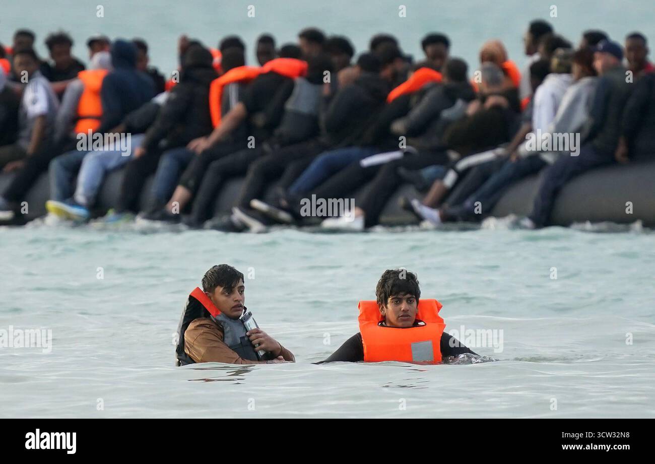 Menschen, die als Migranten gelten, waten durch das Meer, nachdem sie vergeblich versucht hatten, an Bord eines kleinen Bootes in Gravelines, Frankreich, zu gehen. Bilddatum: Donnerstag, 9. Oktober 2025. Stockfoto