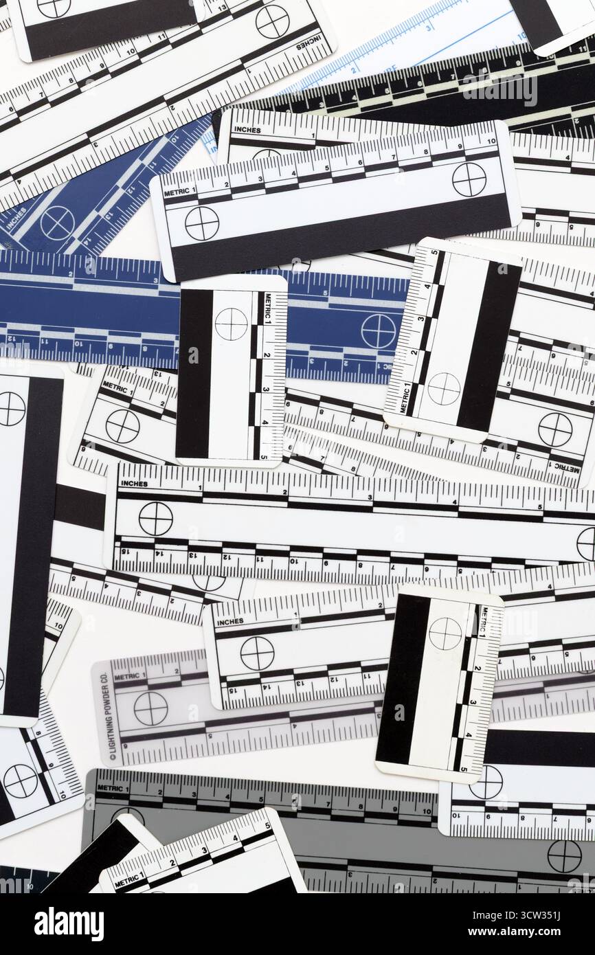 Eine Sammlung forensischer Lineale ist in einem Chaos auf weißem Hintergrund angeordnet. Diese wissenschaftlichen Lineale liefern genaue Messungen in Fotos. Stockfoto