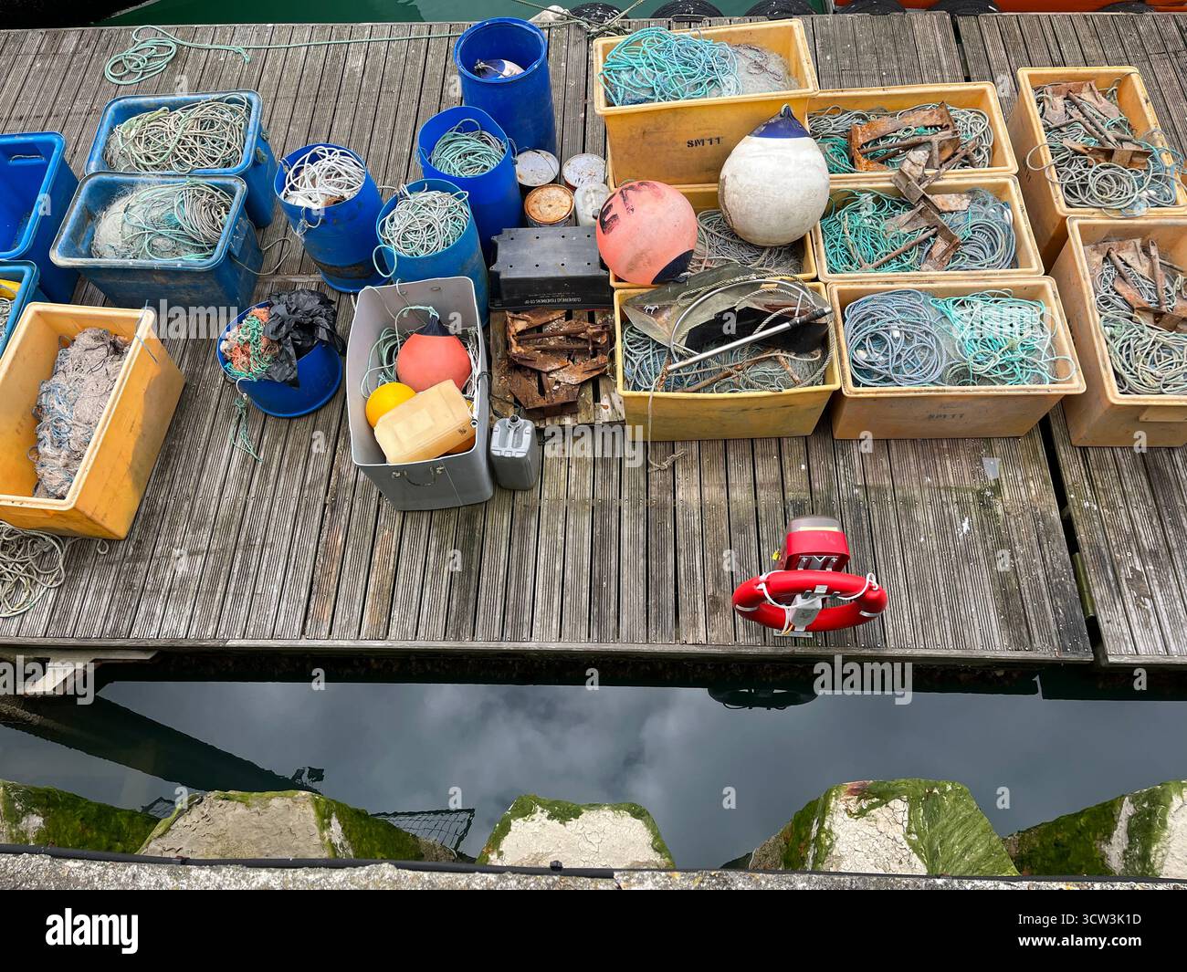 Angelseile und Netze in Fässern und Kisten auf einem Pier - Smartphone-aufgenommenes Stockfoto