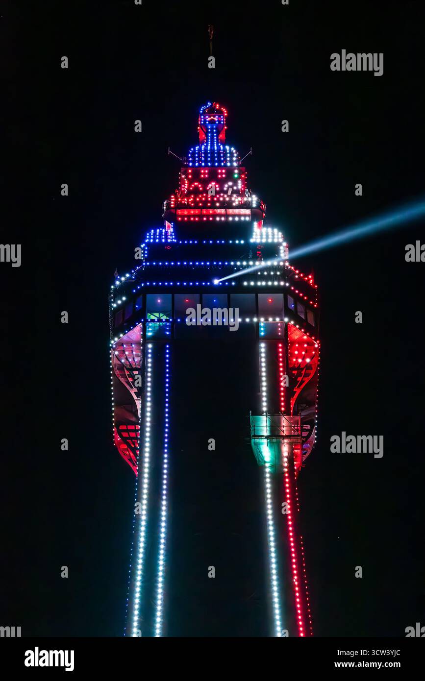 Nahaufnahme der Spitze des blackpool Tower bei Nacht, beleuchtet von roten und blauen Lichtern und strahlt einen Lichtstrahl in den schwarzen Nachthimmel Stockfoto