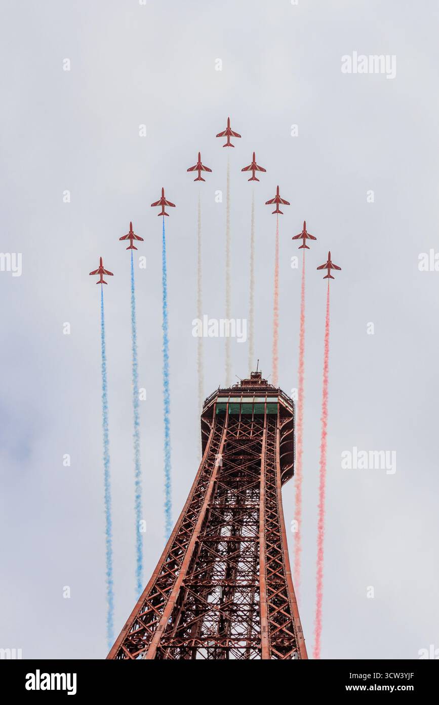 Die roten Pfeile in V-Formation mit rot-weißen und blauen Rauchpfaden bilden dramatische Flypast direkt über dem blackpool Tower Stockfoto