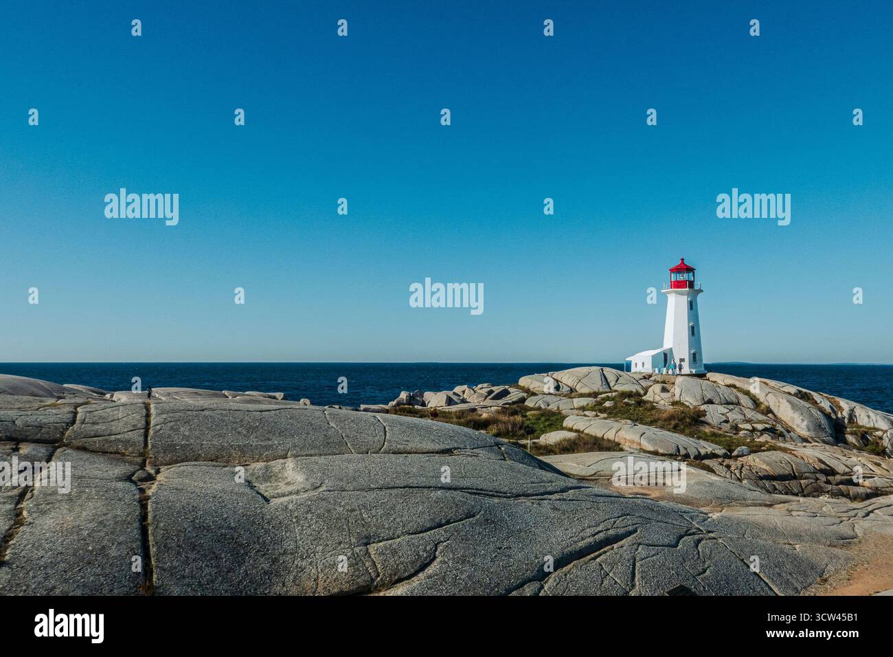 Peggy's Cove, NS - CA - 29. September 2025 das legendäre Peggy's Point Lighthouse steht auf einem großen Granitfelsen mit Blick auf das riesige, tiefblaue A Stockfoto