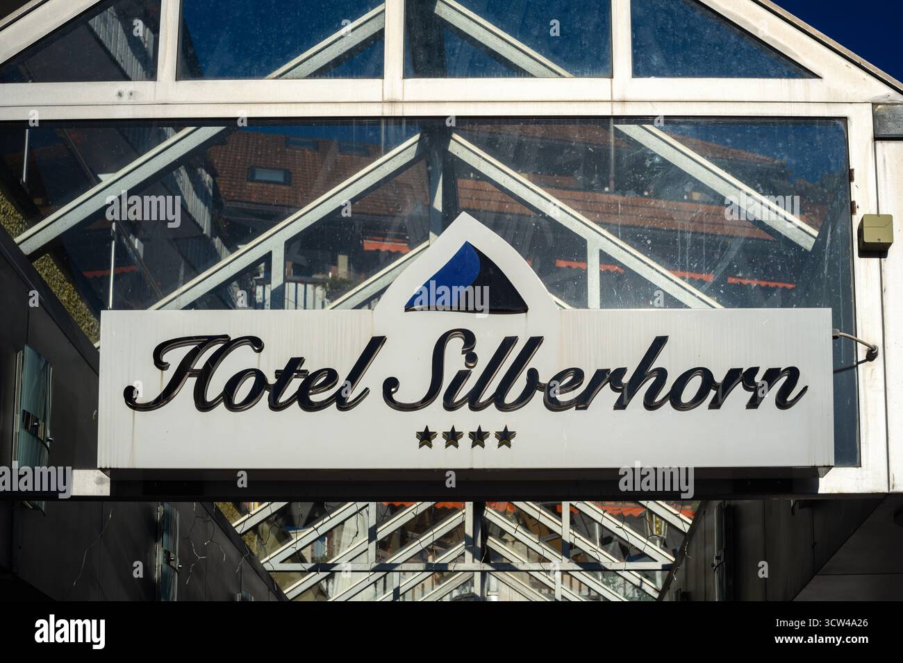 Wengen, Schweiz - 2. Oktober 2025: Ein Schild für das Hotel Silberhorn in modernem Design mit dreieckigem Logo und Glasarchitektur auf der Rückseite Stockfoto