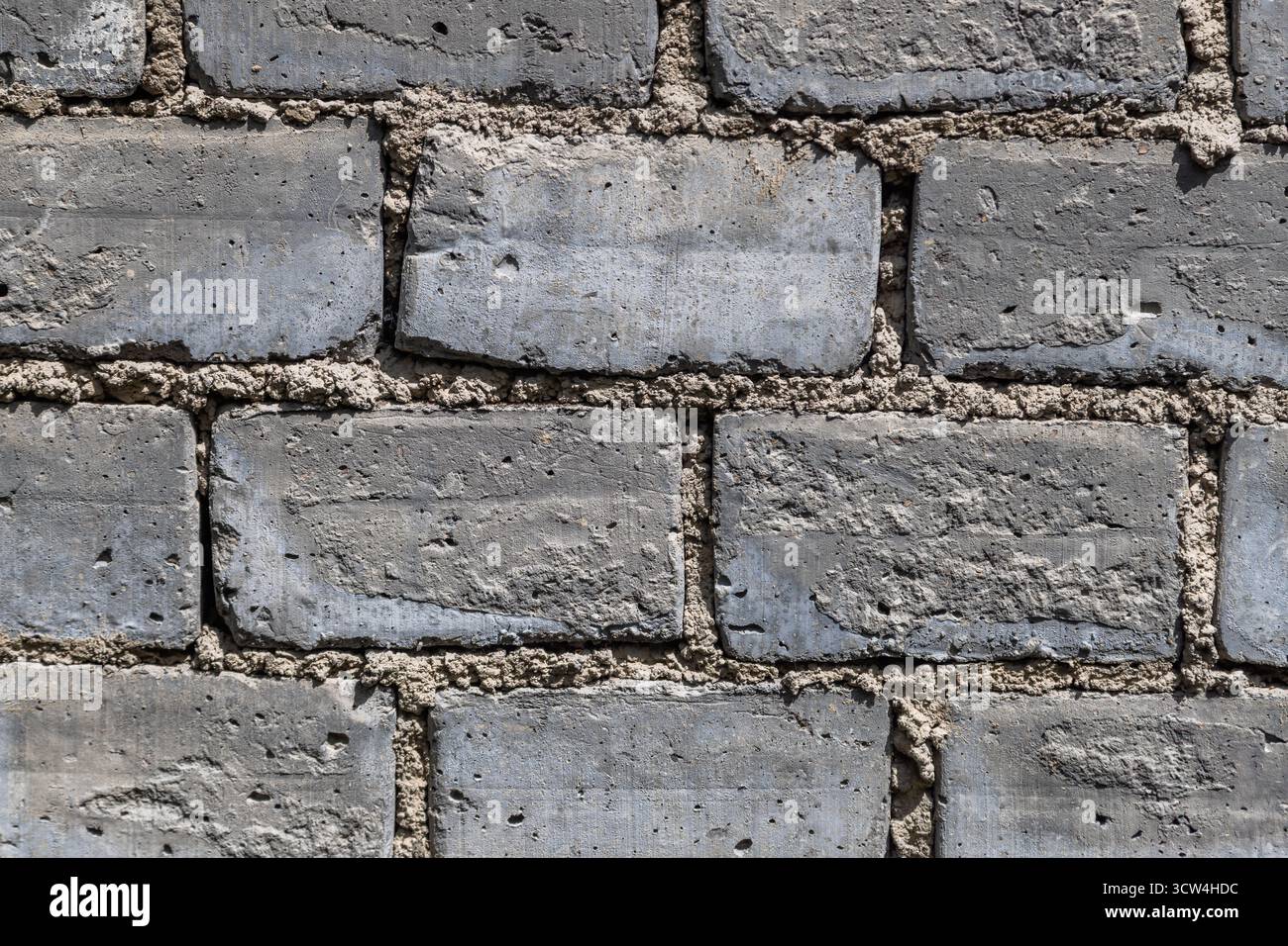 Raue, strukturierte Backsteinwand auf der Baustelle im Freien Stockfoto