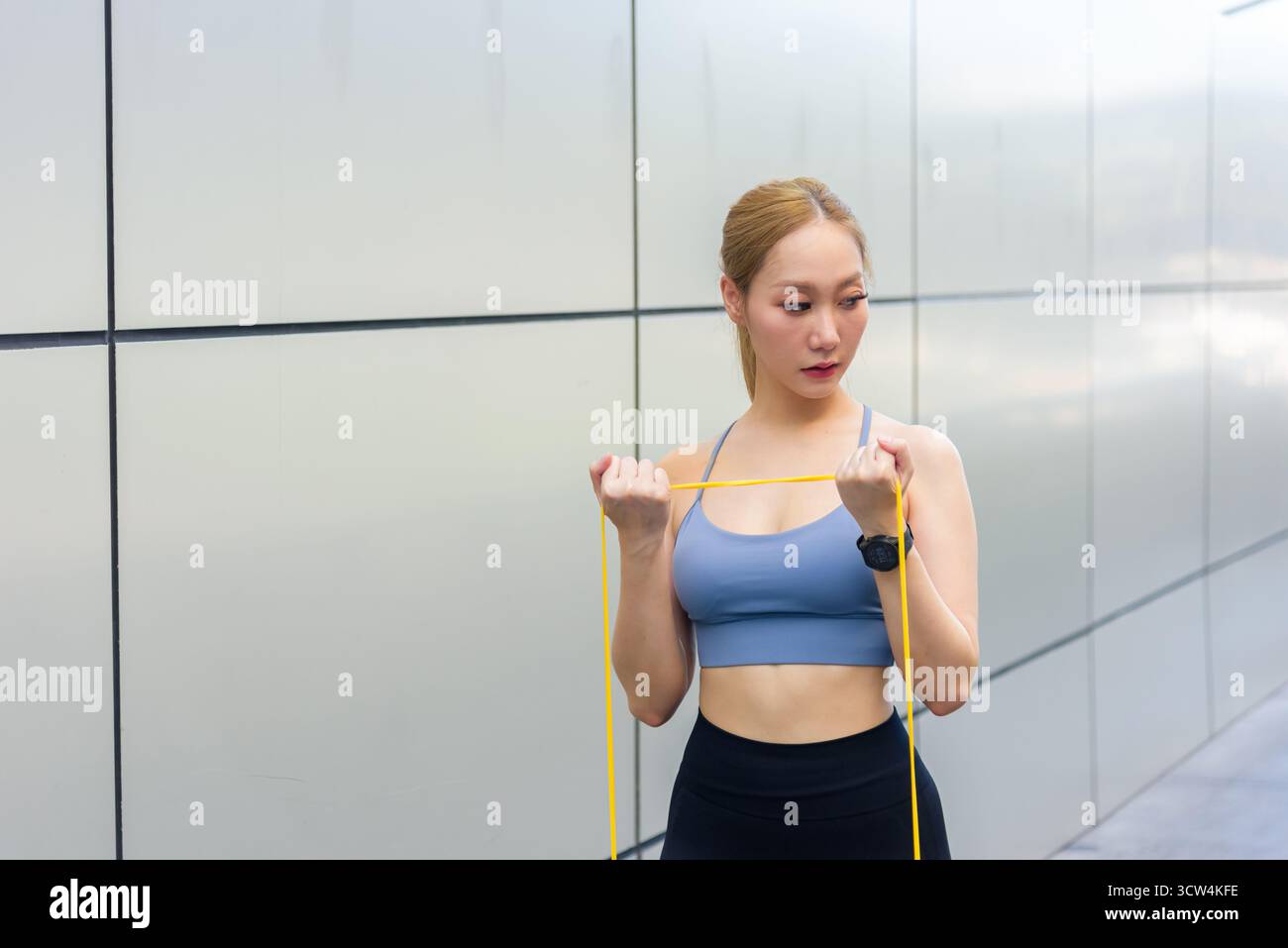 Trainingsroutine für Sport Frau Workout im Freien, Fit Individual führt Bizepskurve mit Gelb Stockfoto