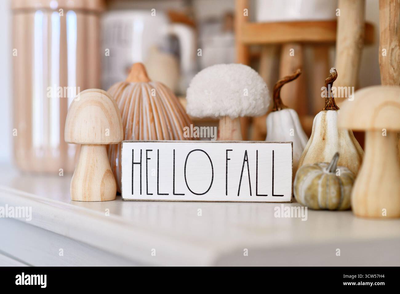 Deutschland - Oktober 2025: Boho Herbstdekor mit Keramikkürbis, Holzpilz und Hello Herbstschild in neutralen Tönen Stockfoto