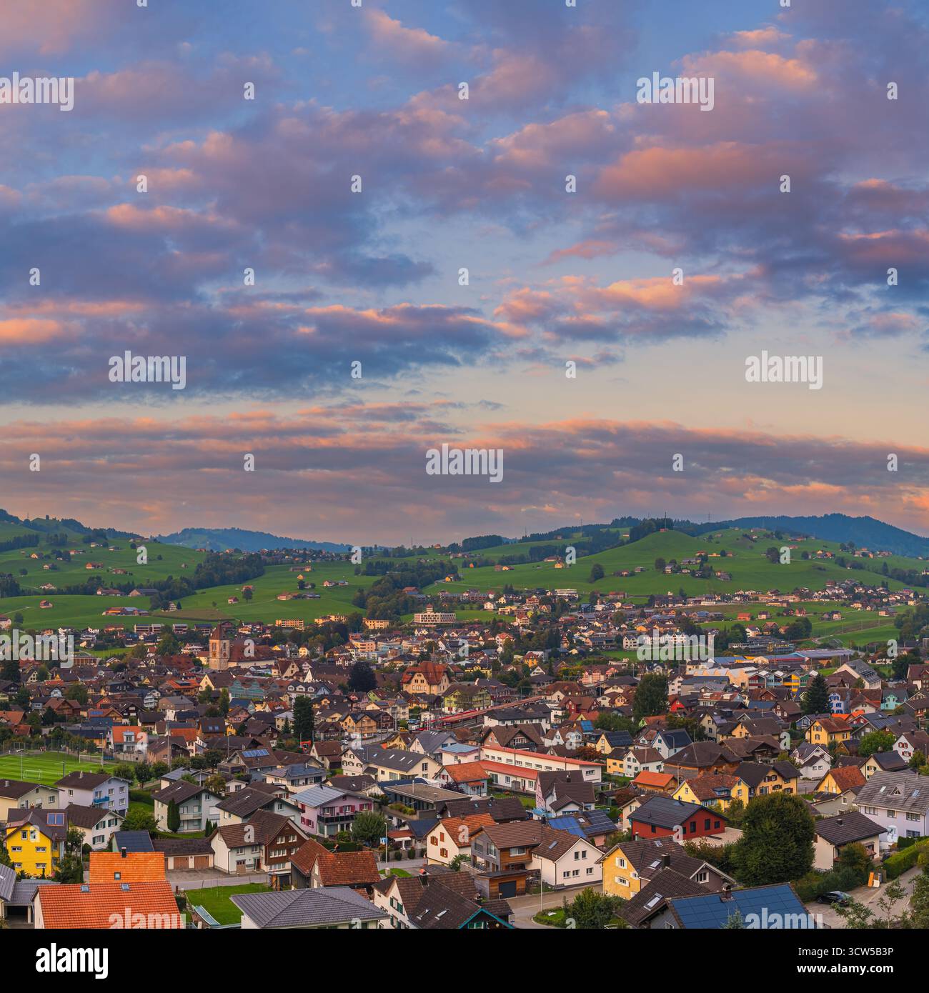 Ein quadratisches 1:1 lebhaftes Foto bei Sonnenuntergang von Appenzell, Schweiz, mit einem farbenfrohen Himmel mit weichen Wolken über der Alpenstadt. Das Abendlicht r Stockfoto