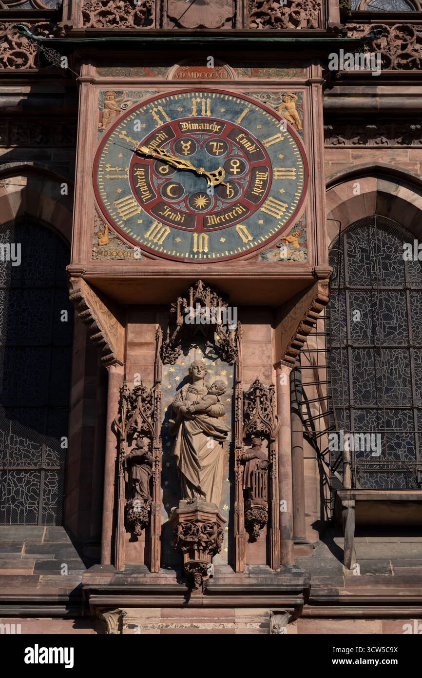 Statue der Jungfrau, flankiert von St. Peter und St. Lawrence und kunstvolle Uhr mit römischen Ziffern auf dem Straßburger Dom de Notre-Dame Portal der VI Stockfoto