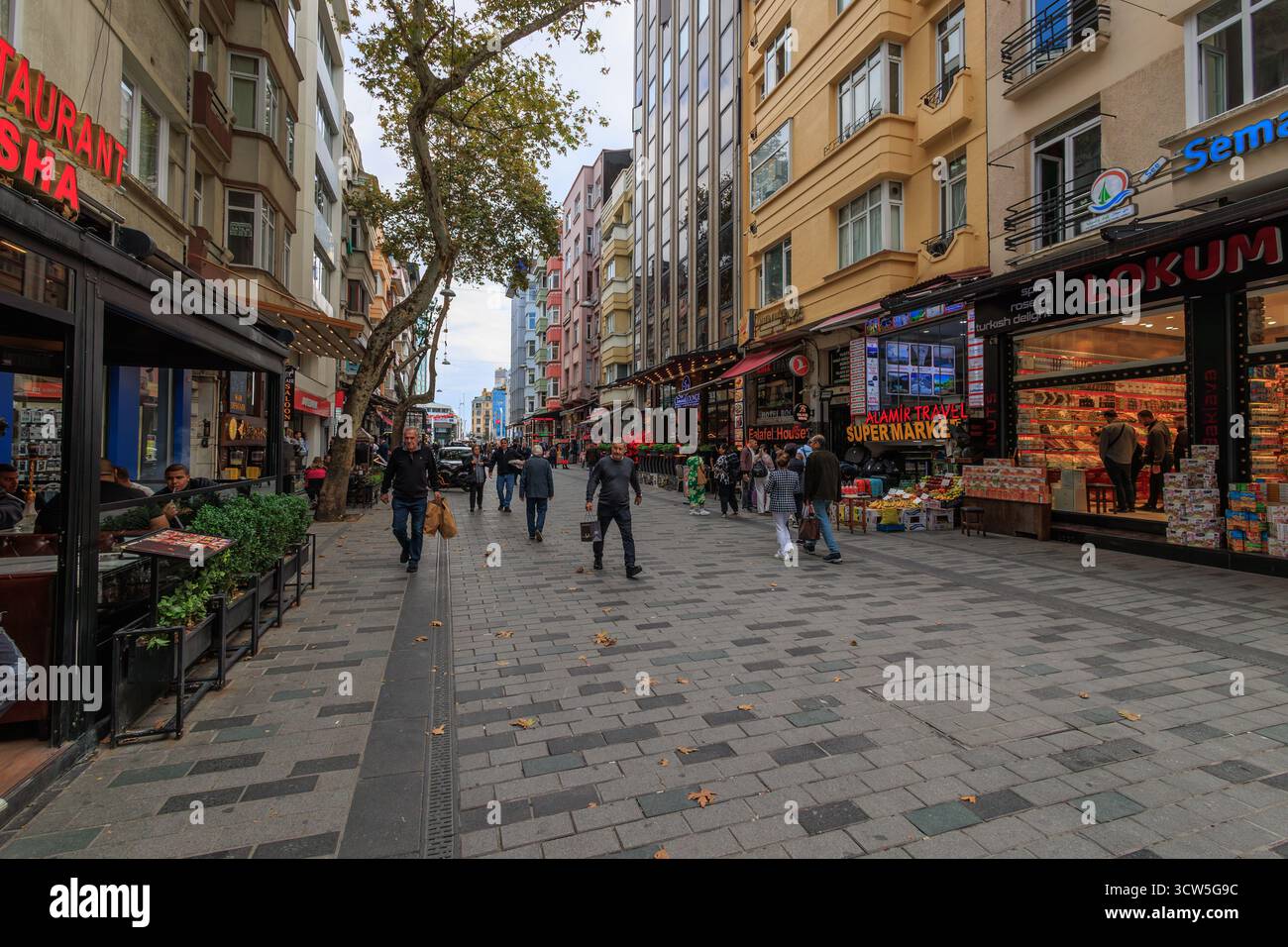 Leute laufen auf der Straße in der Nähe von bunt bemalten Wohnungen in taksim, istanbul Stockfoto