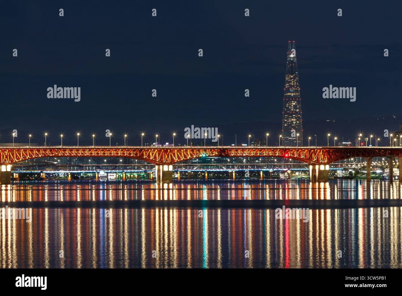 Atemberaubender Blick bei Nacht auf Seoul, Südkorea. Das Bild zeigt die beleuchteten Brücken, die den Han-Fluss mit dem Lotte-Turm überspannen. Stockfoto