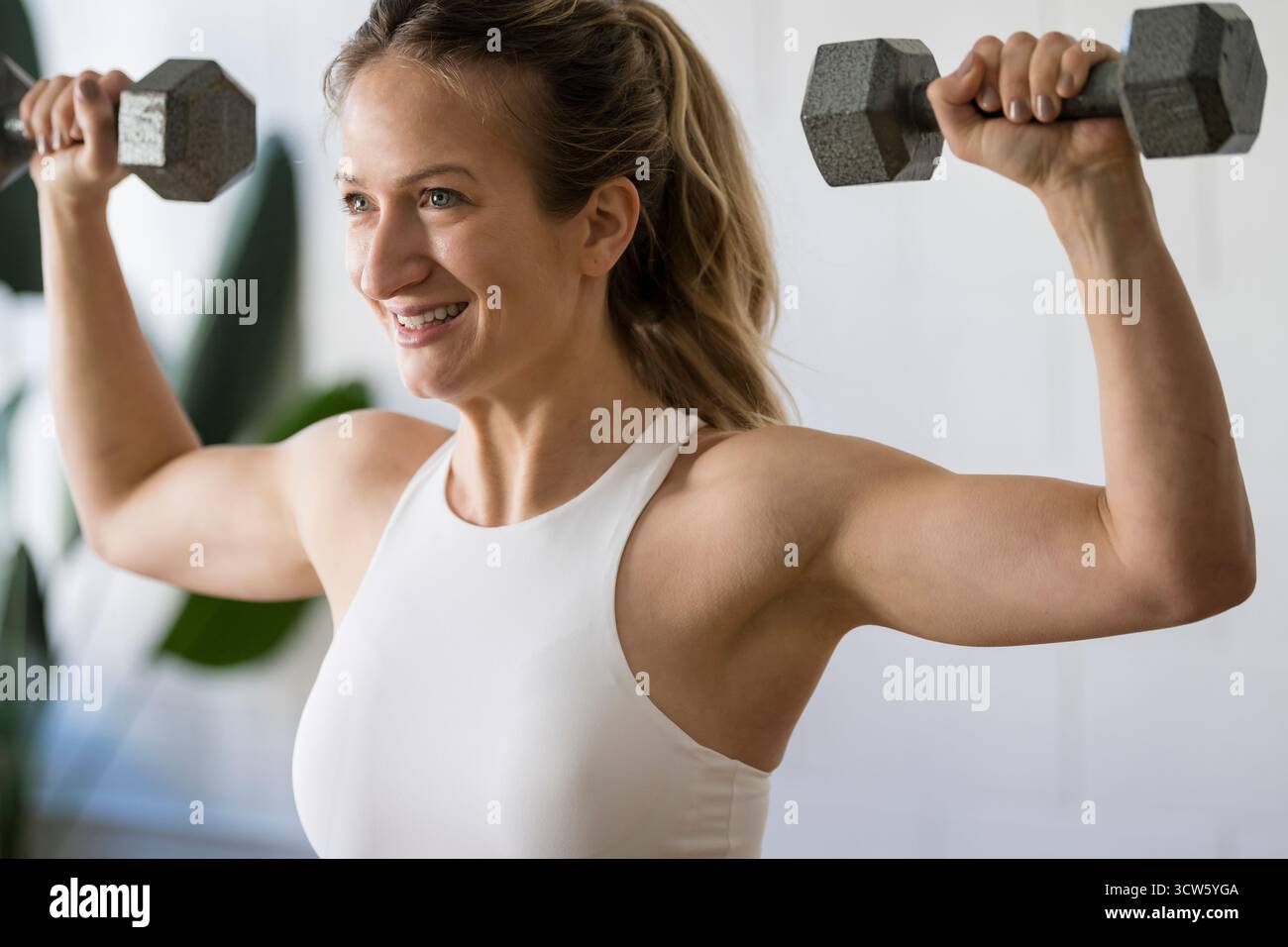 Frau, die mit Kurzhanteln am Bizeps arbeitet Stockfoto
