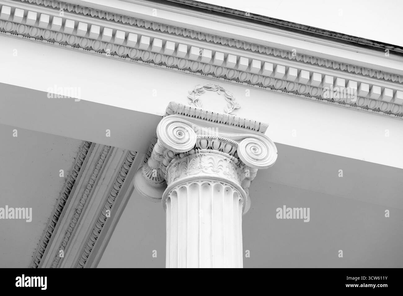 Klassische Architekturdetails, weiße Säulen-Hauptstadt und dekorierte Portikuselemente, Schwarzweiß-Fotografie Stockfoto