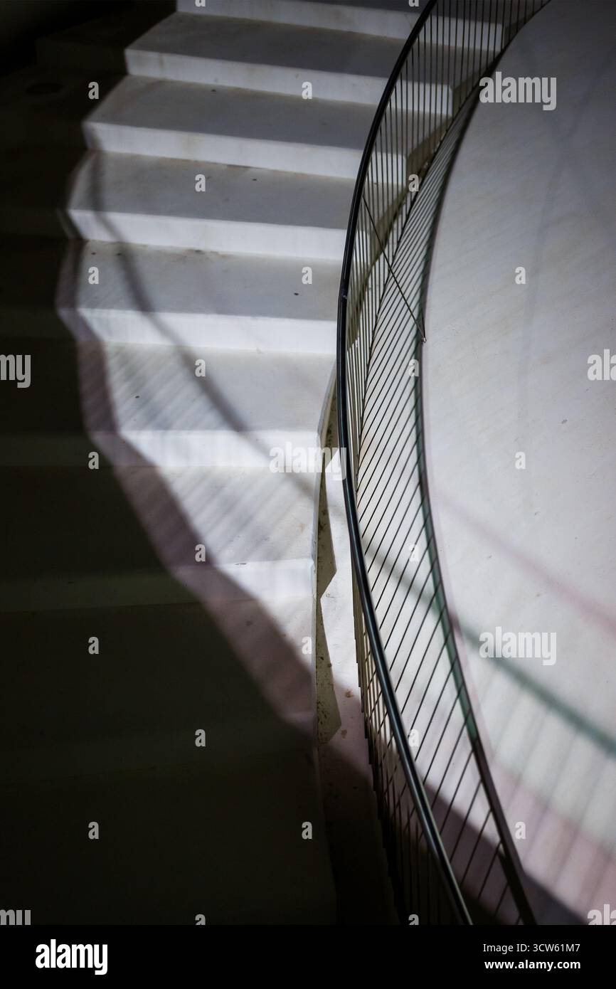 Vertikale Perspektive der beleuchteten geschwungenen Treppe Stockfoto