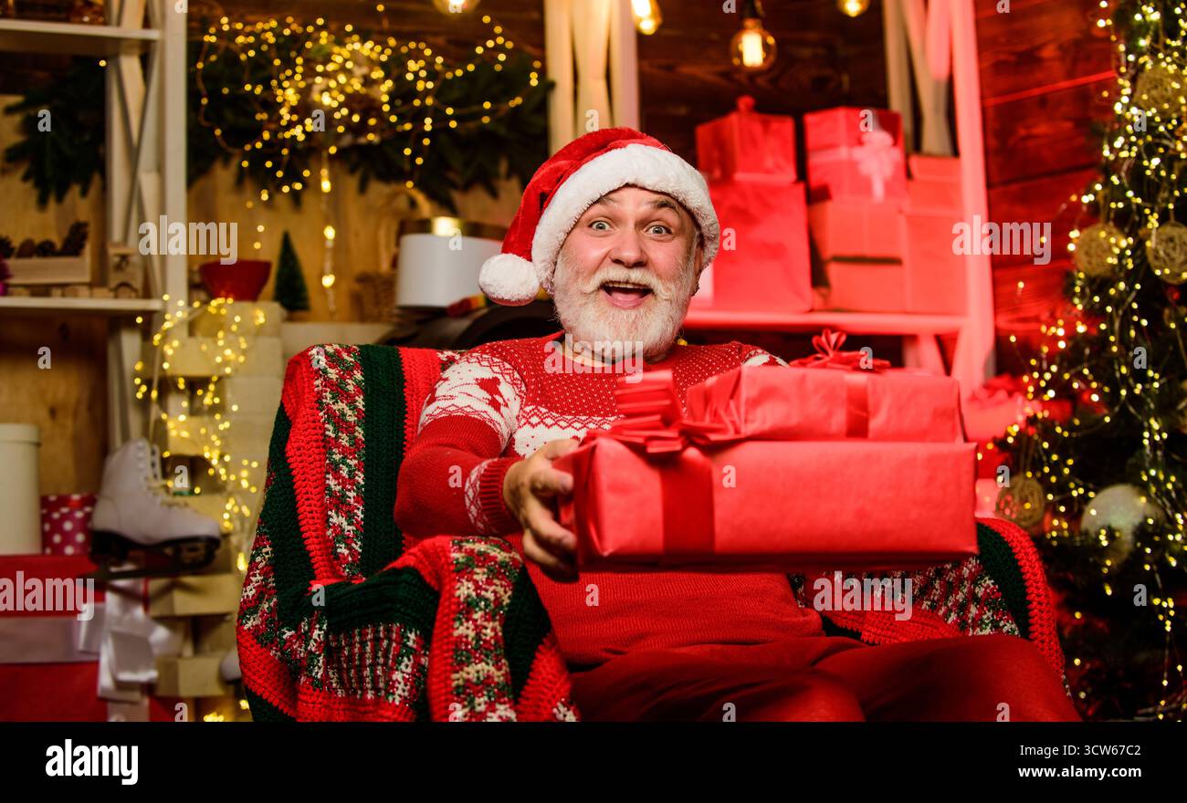 Online-Shop. Bärtiger Mann geht einkaufen. weihnachtsgeschenke. Geschenke bei Tannenbaum. Frohe weihnachten. Shopping im Winter. Partyfeier. Geschenke von Stockfoto