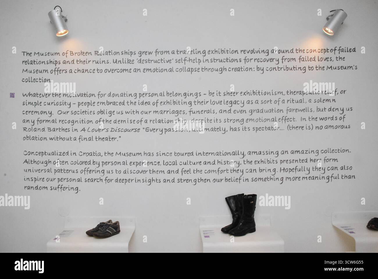 Zagreb, Kroatien - 31. August 2012 - Ausstellung von Schuhen im Museum für gebrochene Beziehungen mit beschreibendem Text an der Wand. Stockfoto