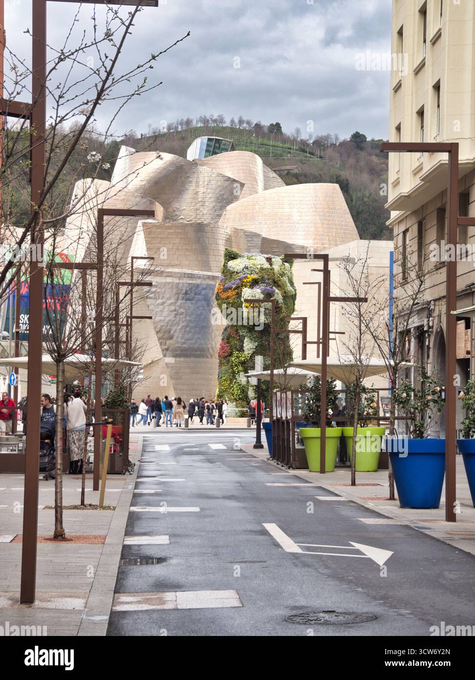 Straßenansicht des Welpen und Guggenheim Museum, Bilbao - Blick auf eine moderne Fußgängerzone in Bilbao, die zu Jeff Koons' ikonischer Welpenskulptur und führt Stockfoto