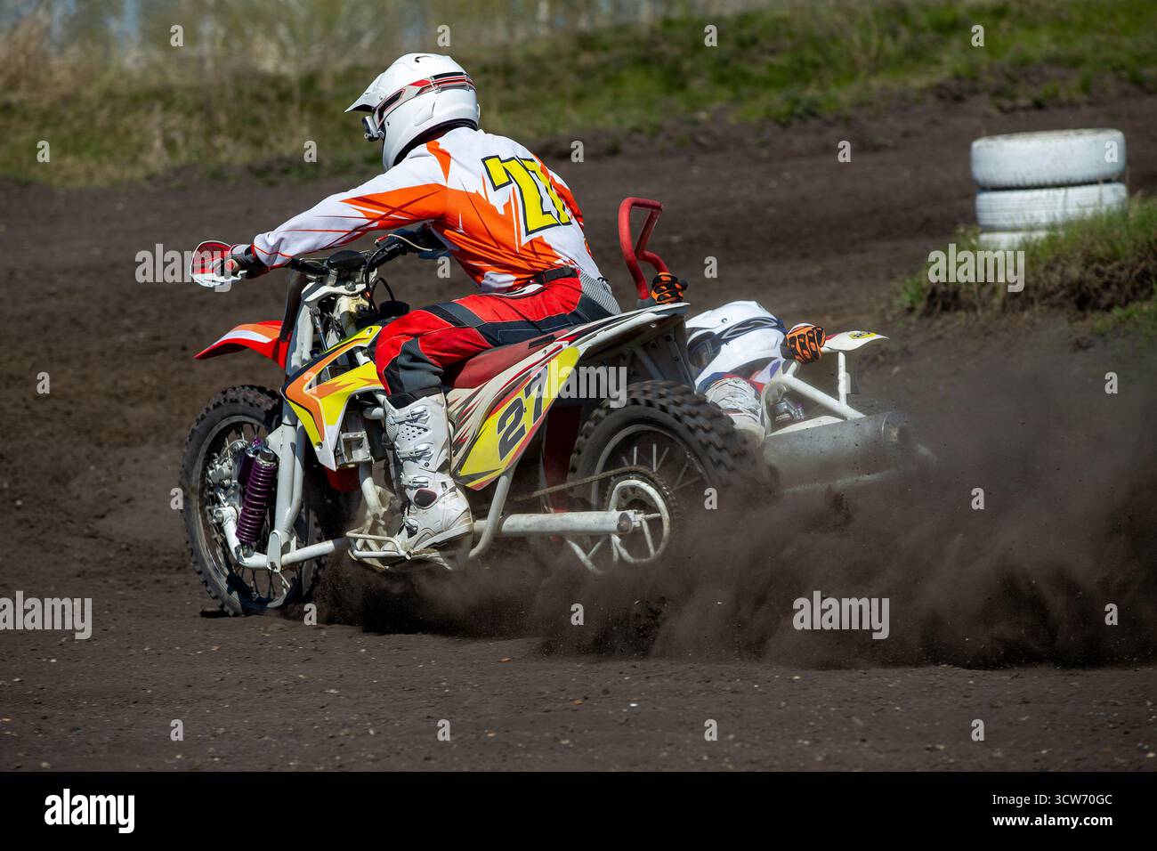 Motocross-Fahrer im Beiwagen führen eine Wende auf staubiger Strecke durch Stockfoto