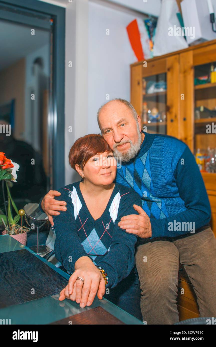 Familienporträt eines Mannes und einer Frau mittleren Alters. Ein Mann mit grauem Bart. Familienessen in entspannter Atmosphäre. Vertikales Foto Stockfoto
