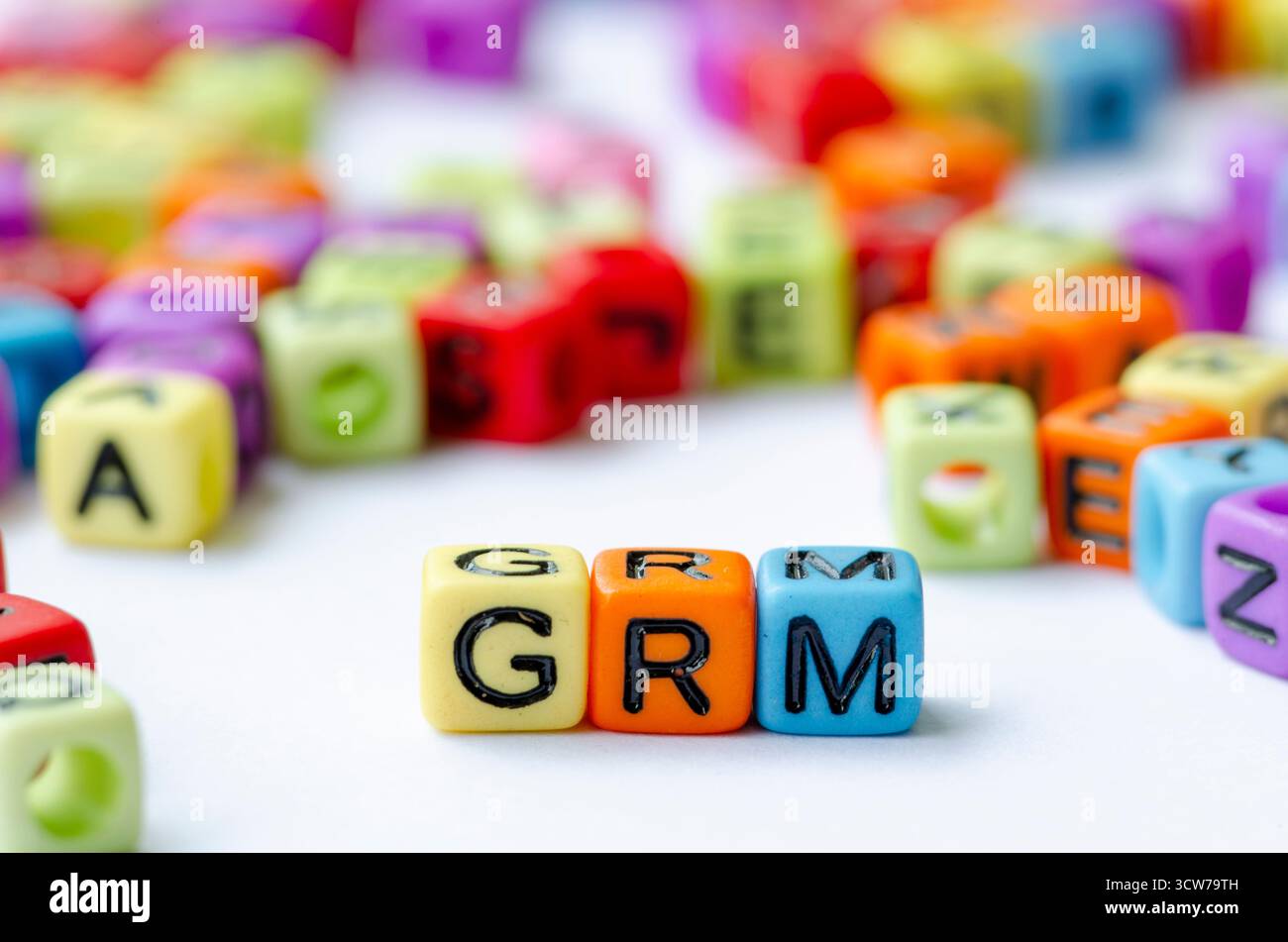 Nahaufnahme des GRM-Textes auf mehrfarbigen Würfeln, die den Beschwerdemechanismus darstellen. Erhaltungskonzept Stockfoto