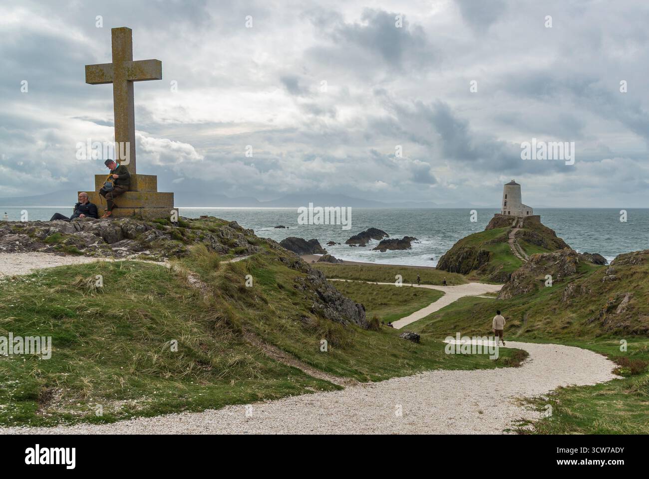 Das Kreuz und der TWR Mawr Leuchtturm auf Llanddwyn Island, Anglesey, Nordwales, Großbritannien. Aufgenommen am 1. Oktober 2025. Stockfoto