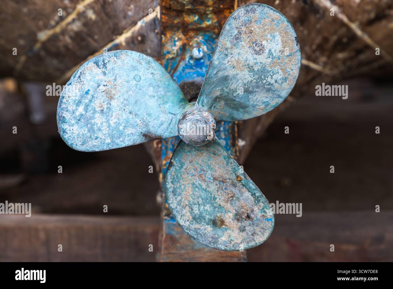 Nahaufnahme eines verwitterten Bootspropellers mit blauer Farbe, Rost und strukturiertem Metall. Eine nautische, industrielle Stimmung, perfekt für alternde Maschinen, Ma Stockfoto