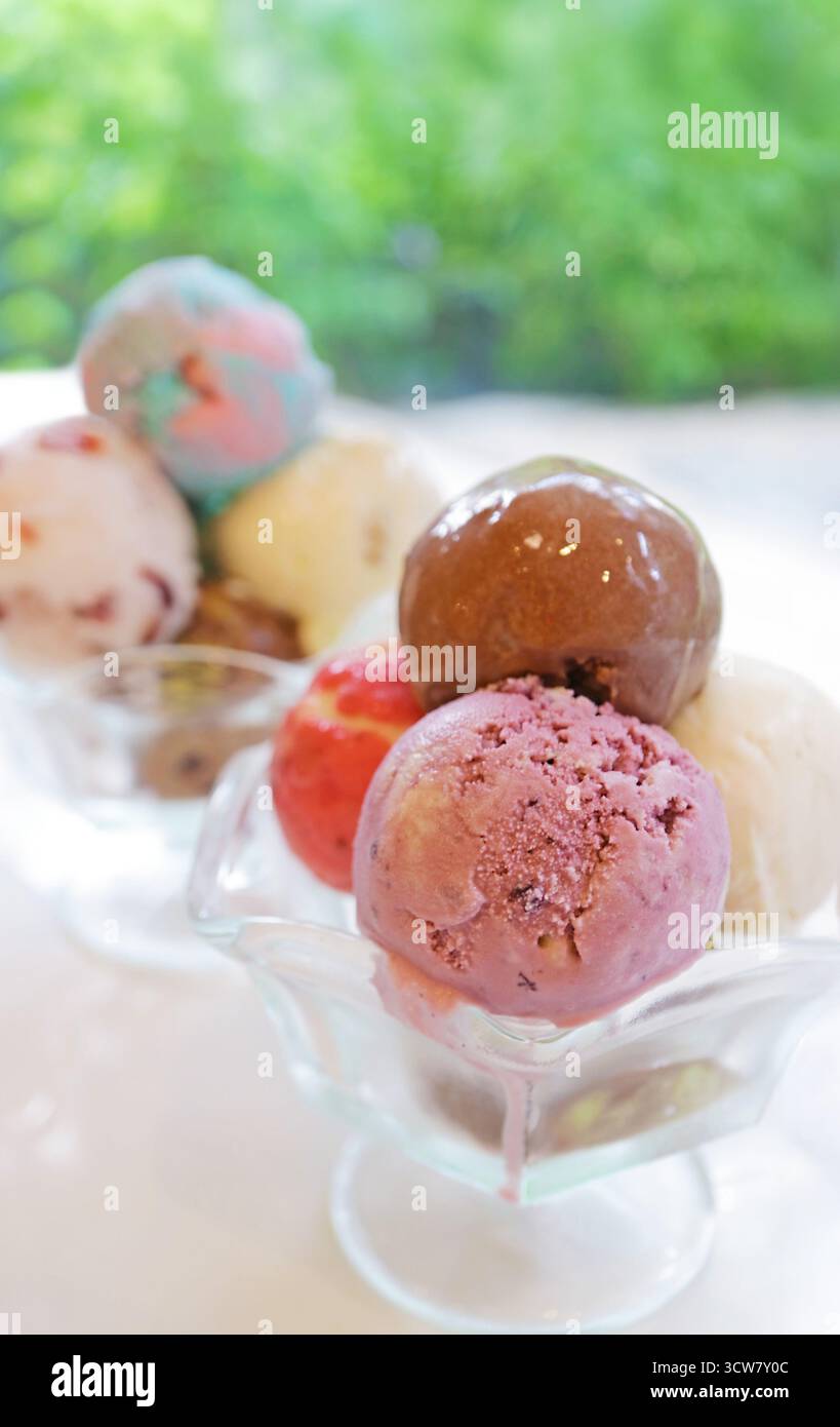 In einer Glasschüssel stapeln sich Löffel mit köstlichem Eis Stockfoto