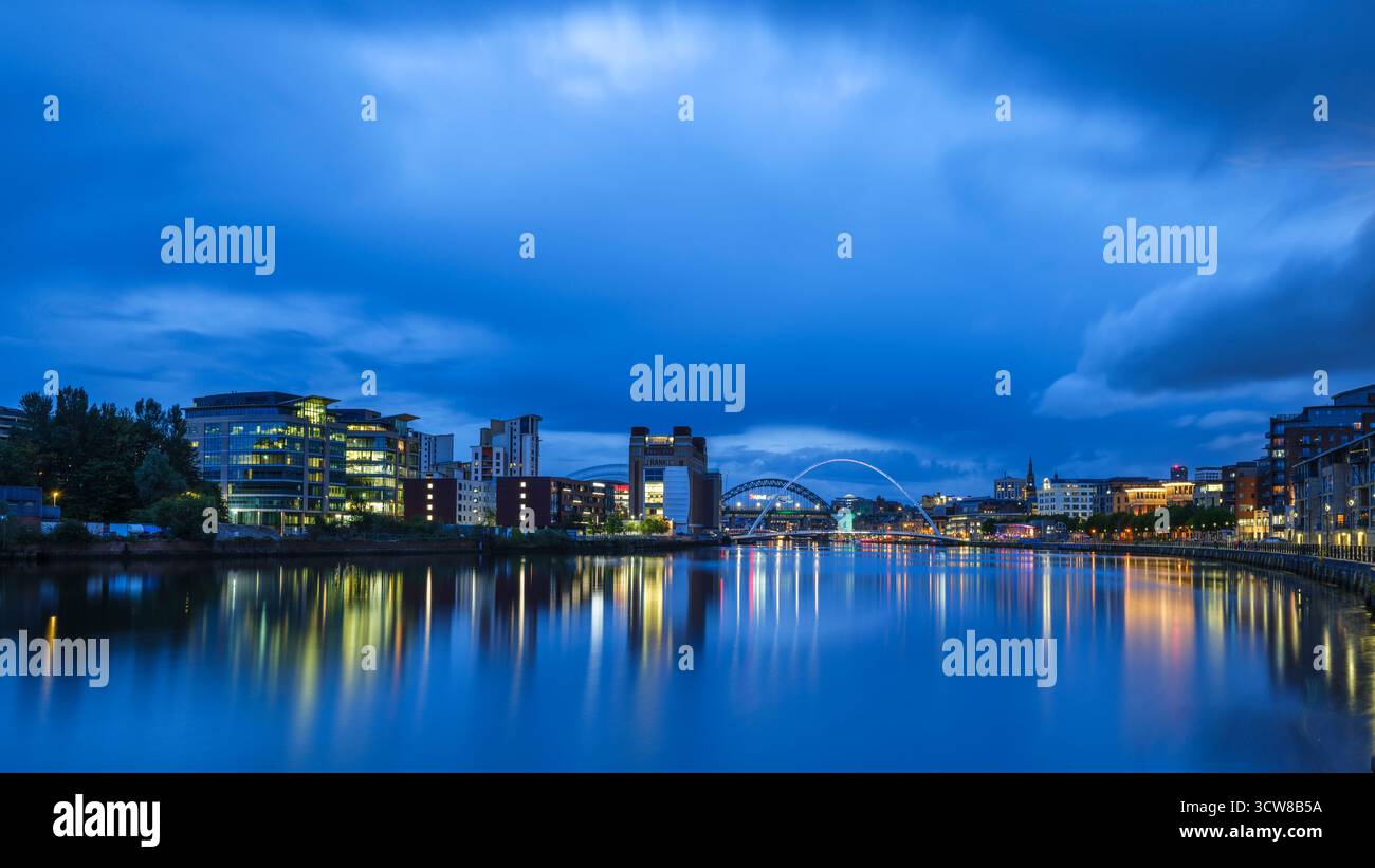 England, Tyne und Wear, Newcastle upon Tyne. Abenddämmerung der Gateshead Millennium Bridge, Tyne Bridge und Baltic Building am Fluss Stockfoto