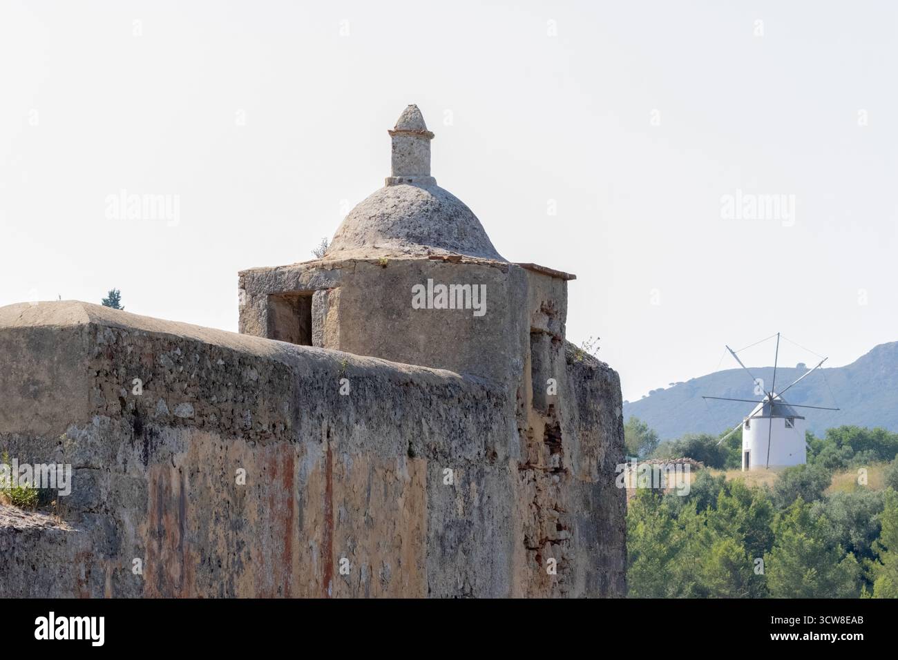 Zerbröckelnde Bastion der historischen Festung sao filipe mit einer traditionellen portugiesischen Windmühle im Hintergrund, setubal, portugal Stockfoto