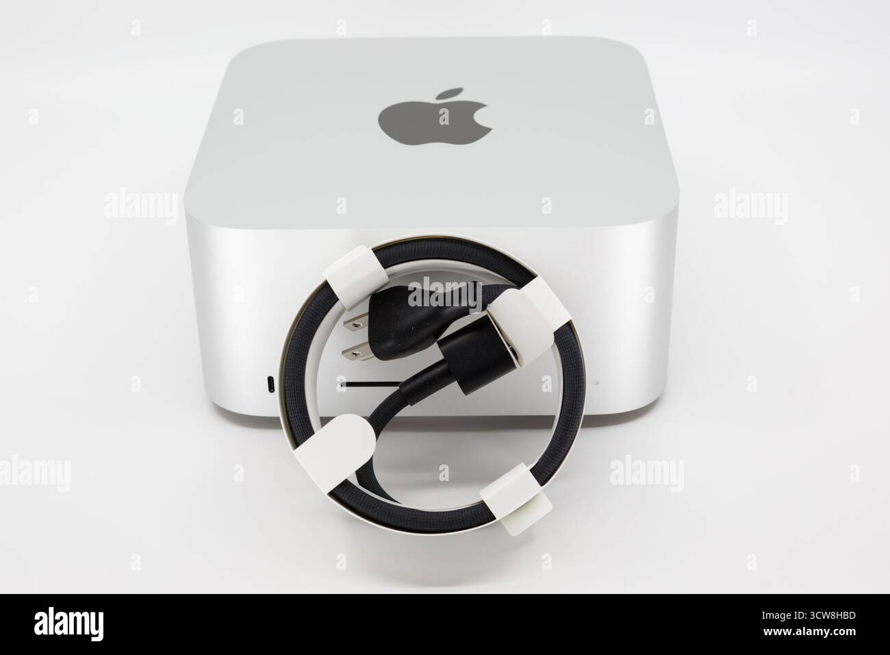 Ein neues, ordentlich gewickeltes Netzkabel und Apple Studio Mac Computer. Stockfoto