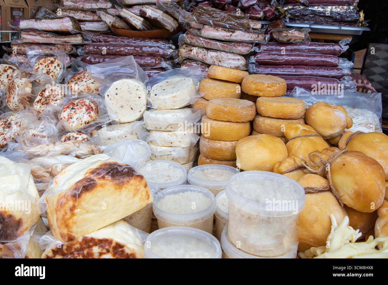 Gemischter geräucherter Speck und farbenfrohe Käsesorten auf dem traditionellen ukrainischen Bauernmarkt. Natürliche, selbstgemachte Bio-Lebensmittel von lokalen Bauern. Stockfoto