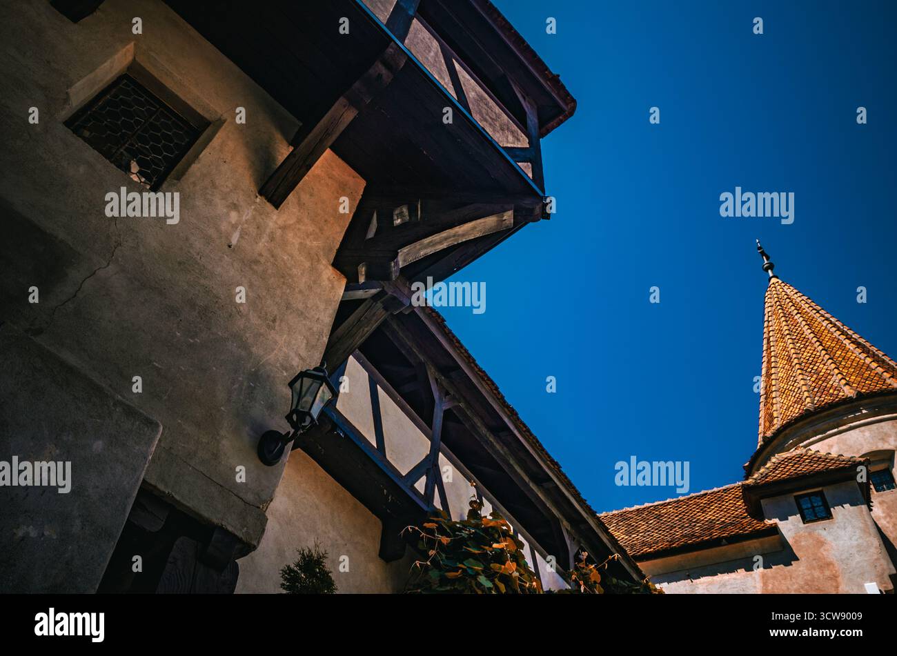 Dramatischer Blick auf die mittelalterliche Schlossarchitektur und den Terrakotta-Turm vor einem tiefblauen Himmel Stockfoto