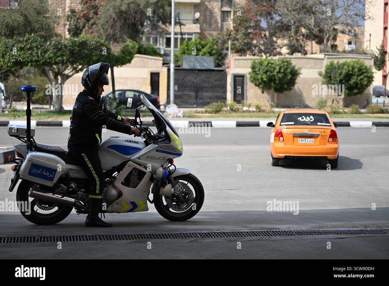 Ismailia, Ägypten – Ein Verkehrspolizist fährt mit einem Motorrad, während er den Verkehr auf den Straßen der Stadt steuert und lenkt. Stockfoto