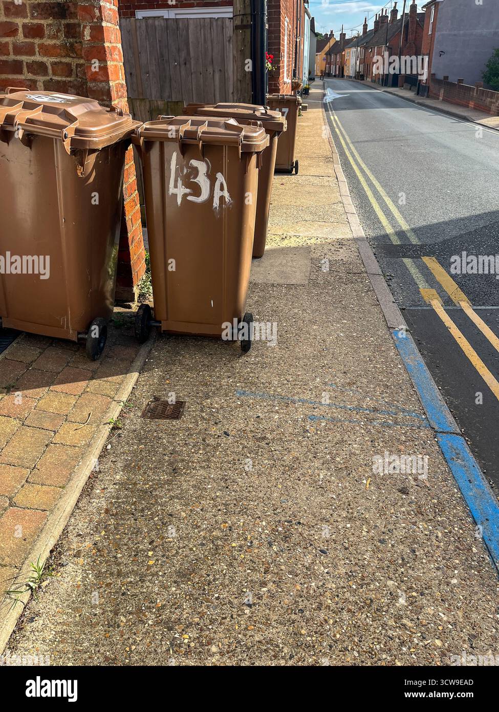 Englische braune Gartenmüllbehälter auf der Straße, bereit zur Sammlung. - Smartphone-aufgenommenes Stockfoto