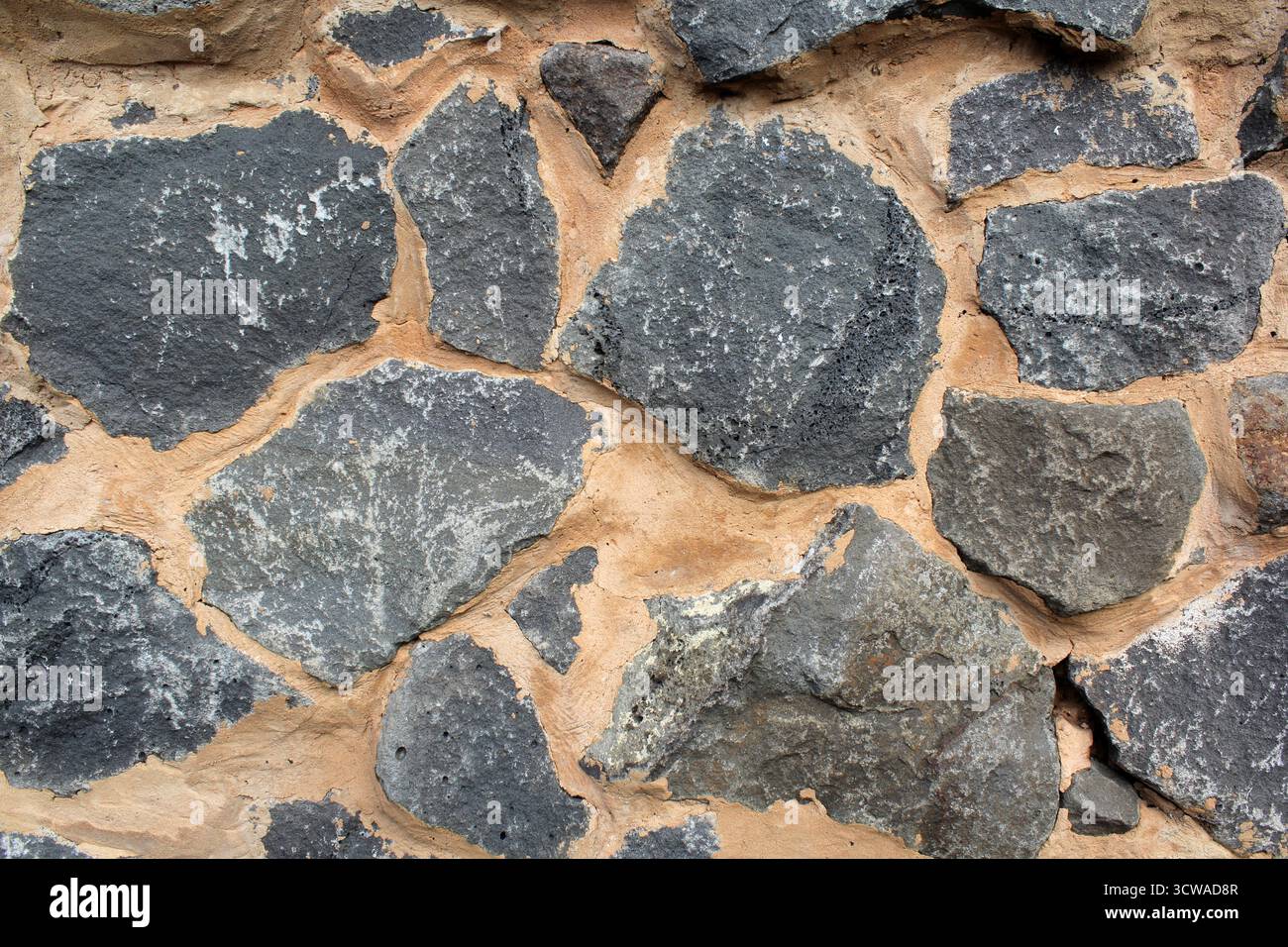 Graue Steinwand mit sandfarbenem, strukturiertem abstraktem Hintergrund aus Mörtel Stockfoto