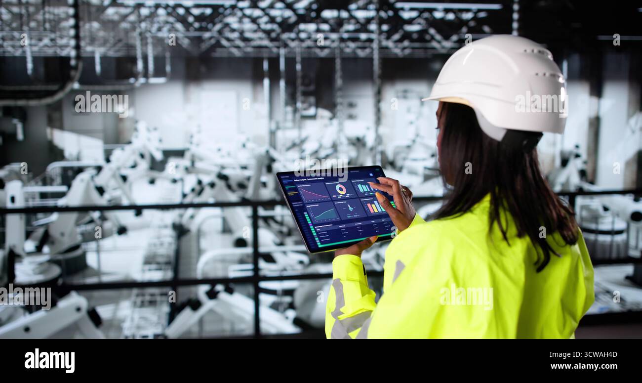 Schwarze Amerikanische Frau Inspiziert Auto-Montagelinie Mit Robotertechnologie Stockfoto
