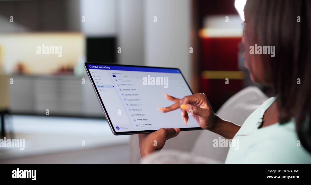 Afrikanische Frau, Die Am Arbeitsplatz Finanzgeschäfte Mit Einem Elektronischen Tablet Betreibt Stockfoto