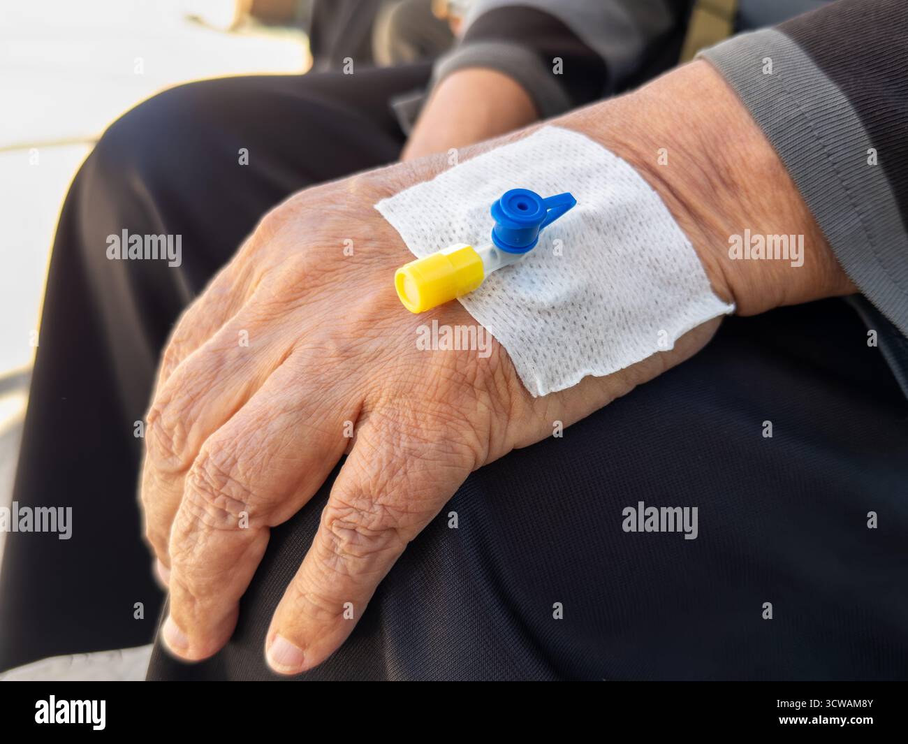 Nahaufnahme älterer Hand mit IV-Katheter in der Krankenhausversorgung Stockfoto
