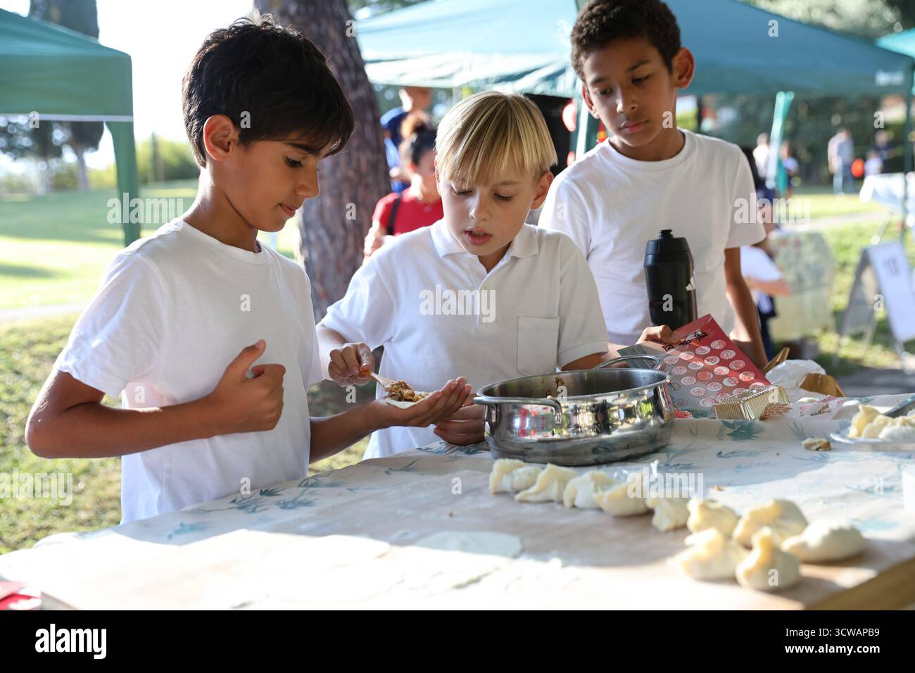 Rom, Italien. Oktober 2025. Die Schüler machen Jiaozi, oder chinesische Knödel, während eines halbherbstlichen Jahrmarkts an der Marymount International School in Rom, Italien, am 10. Oktober 2025. Der Jahrmarkt fand hier am Freitag statt, wo Studenten und Anwohner eine Vielzahl chinesischer kultureller Aktivitäten und Vorstellungen von lokalen Enthusiasten der chinesischen Kultur genossen. Quelle: Li Jing/Xinhua/Alamy Live News Stockfoto