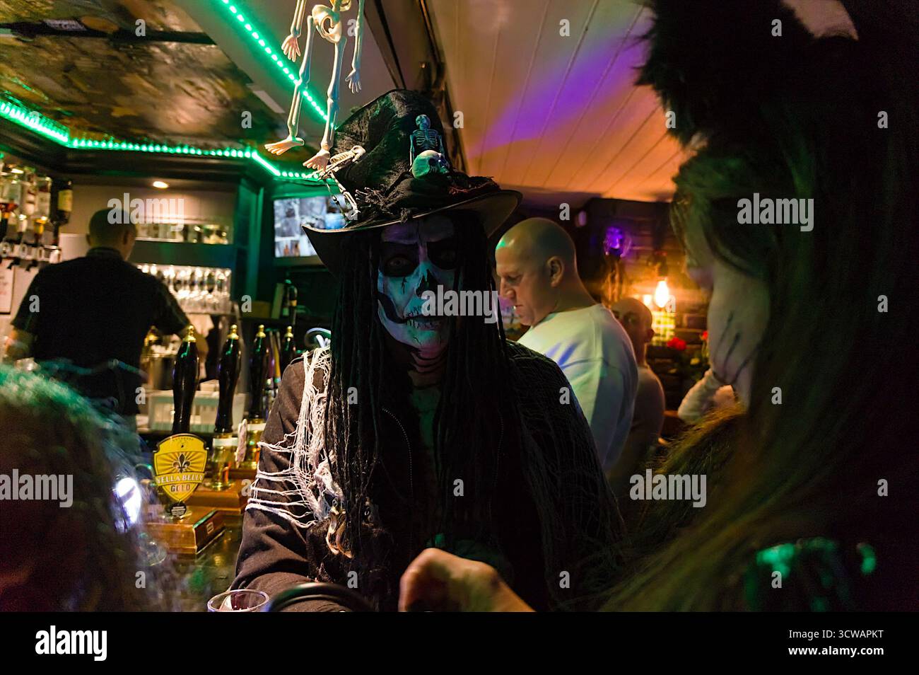Ich trage eine Totenkopfmaske mit Hut auf einer halloween-Party im Carpenters Arms Pub Stockfoto