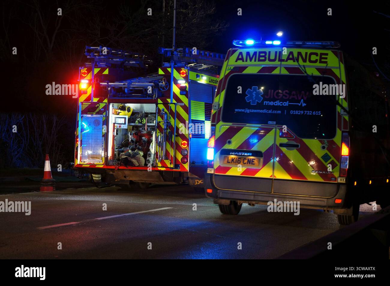 Unfallort auf der Spalding-Straße bei Nacht mit blinkenden Lichtern von Rettungsfahrzeugen Stockfoto