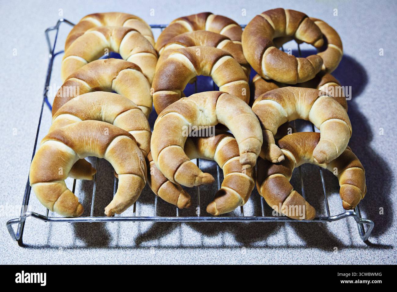 Eine Reihe goldbrauner Croissants auf einem Rost, frisch aus dem Ofen, Weinviertel Niederösterreich Stockfoto