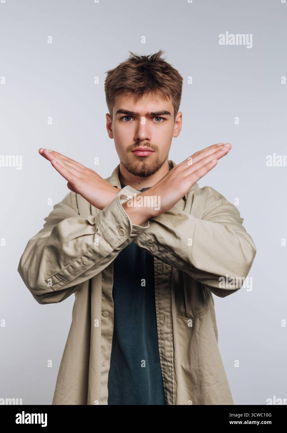 Porträt eines jungen Mannes, der seine Arme mit Autorität kreuzt, das Vertrauen symbolisiert und klare Grenzen auf weißem Hintergrund setzt Stockfoto Porträt eines jungen Mannes, der seine Arme mit Autorität kreuzt, das Vertrauen symbolisiert und klare Grenzen auf weißem Hintergrund setzt Stockfoto