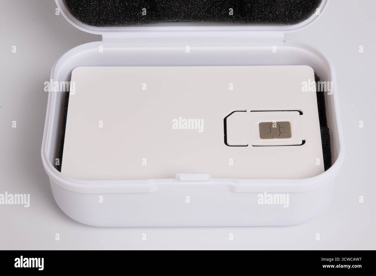 Nahaufnahme einer neuen Handy-SIM-Karte in der weißen Trägerverpackung über einer offenen Aufbewahrungsbox Stockfoto