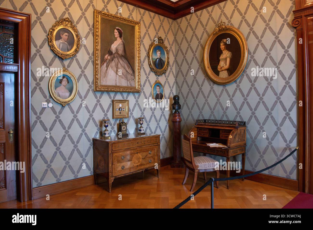 Deutschland, Sigmaringen, 02.10.2025 das Schloss Sigmaringen, auch Hohenzollernschloss, ist ein ehemaliges fuerstliches Residenzschloss und Verwaltungssitz der Fürsten von Hohenzollern-Sigmaringen. Das Schloss Thrront auf einem die Donau einengenden, lang gestreckten Kalkfelsen des Weißjuras, dem Schlossberg. Der Felsruecken ist rund 200 Meter lang und erhebt sich bis zu 35 Meter ueber die Donau. Foto: Der blaue Salon war als Schreibzimmer genutzt. Hier sieht man Portraets der fürstlichen Familie Fürstin Josephine, Prinz Leopold, Prinz Anton und Stephanie de Beauharnais. Hohenzollernschloss Stockfoto