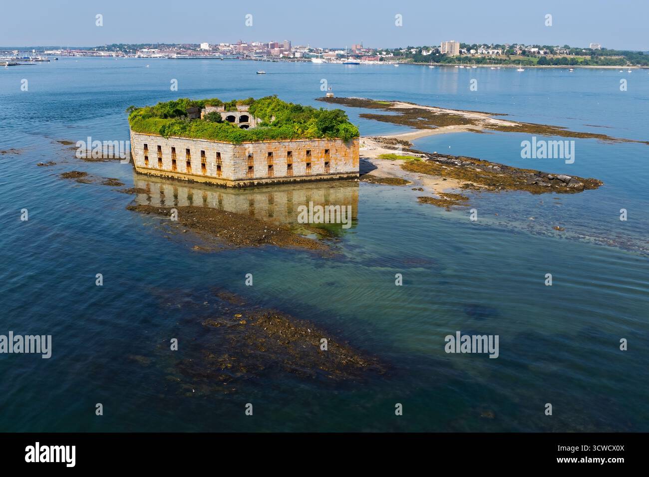 Ein einsames, verlassenes Fort Gorges liegt auf einer kleinen, felsigen Insel, umgeben von ruhigem blauem Wasser. Mit Vegetation bewachsen, der verwitterte Stein des Forts Stockfoto